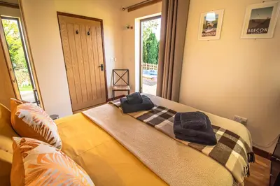 a bedroom with a bed with two towels on it at Sycamore Lodge in Rhayader