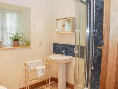 a bathroom with a sink and a shower at The Old Mill in Llanfihangel Rhydithon