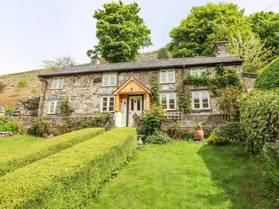 an old stone house with a garden in front of it at Haulfryn in Llangynog