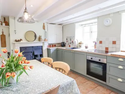 a kitchen with a table and chairs and a kitchen with a fireplace at Haulfryn in Llangynog