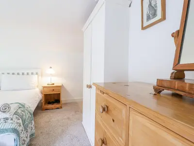 a bedroom with a bed and a dresser with a mirror at Haulfryn in Llangynog