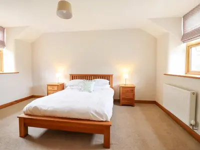 a bedroom with a bed with two night stands and two lamps at Ty Gwyn in Llangwm