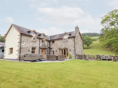 an exterior view of a stone house with a large yard at Ty Gwyn in Llangwm