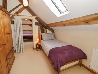 a attic bedroom with a bed and a bunk room at The Gallery in Craven Arms