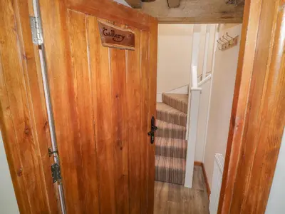 a hallway with a wooden door and a staircase at The Gallery in Craven Arms