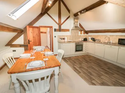 a kitchen with a wooden table and white cabinets at The Gallery in Craven Arms