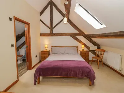 a attic bedroom with a bed and a window at The Gallery in Craven Arms