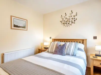 a bedroom with a bed and two night stands and two lamps at The Granary in Llanfair Caereinion