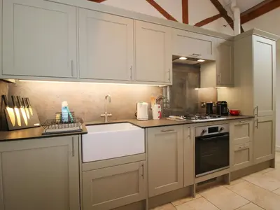 a kitchen with white cabinets and a sink at The Milking Parlour in Leominster
