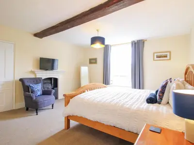 a bedroom with a bed and a chair at The Laurels in Bishops Castle