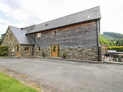 a large brick building with a table in front of it at The Hayloft in Knighton