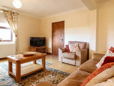 a living room with a couch and a table at Ty Newydd in Pont Dolanog