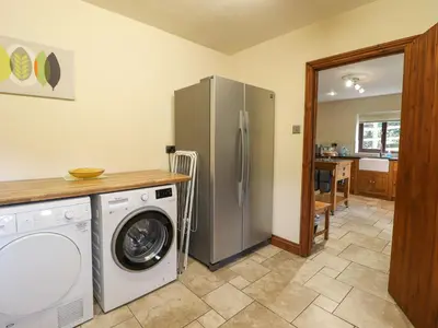 a kitchen with a washing machine and a refrigerator at Ty Newydd in Pont Dolanog