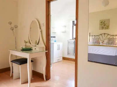 a bedroom with a mirror and a table and a bed at Ty Newydd in Pont Dolanog