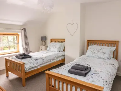 a bedroom with two beds and a heart on the wall at The Farmhouse in Capel Bangor
