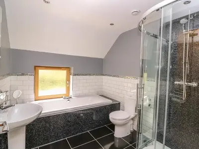 a bathroom with a tub and a toilet and a sink at The Farmhouse in Capel Bangor