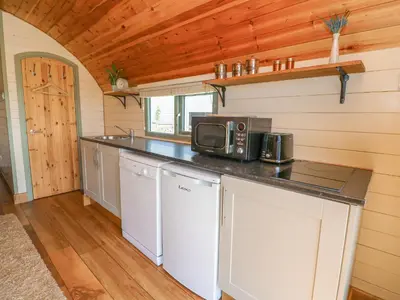 a kitchen in a tiny house with a microwave at Valley View in Rhayader