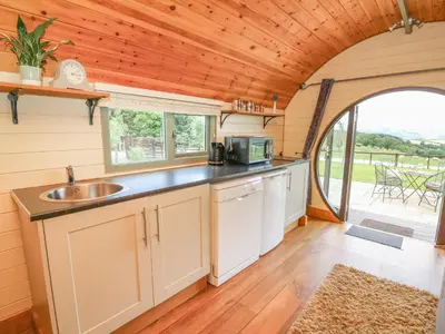 a kitchen in a tiny house with a large window at Valley View in Rhayader