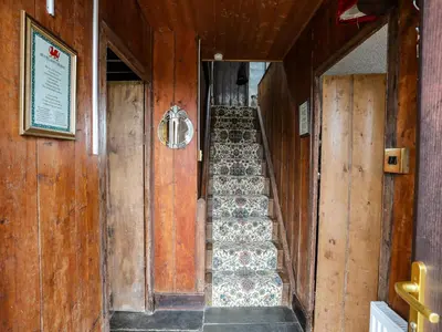 a stairway in a building with wooden walls and wooden floors at Hendy Cottage in Llanbedr