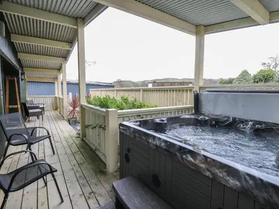 a hot tub on the deck of a house at Y Felin - Moana in Borth
