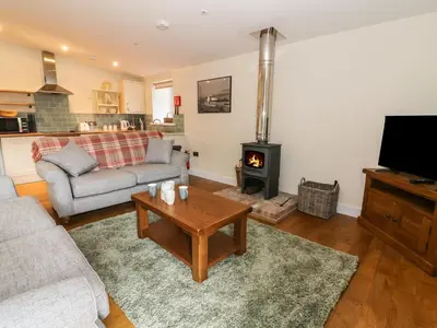 a living room with a couch and a wood stove at Y Felin - Moana in Borth