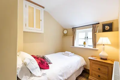 a bedroom with a white bed and a window at Pen Y Bont in Llangollen