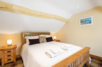a bedroom with a large bed with two towels on it at Pen Y Bont in Llangollen