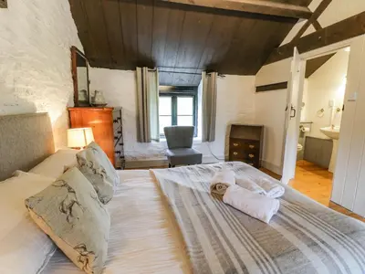 a bedroom with a bed with a stuffed animal on it at The Corn Store in Corwen