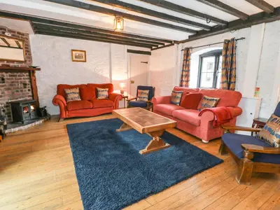 a living room with red couches and a coffee table at The Corn Store in Corwen