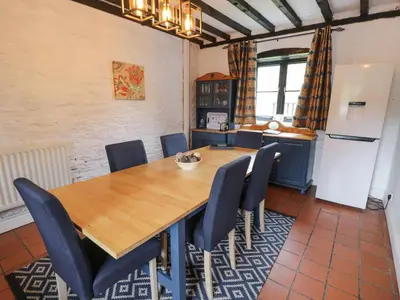 a dining room with a wooden table and chairs at The Corn Store in Corwen