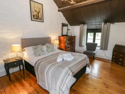 a bedroom with a bed with towels on it at The Corn Store in Corwen
