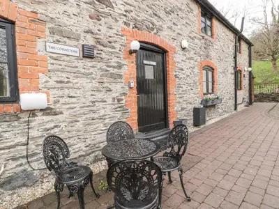 a table and chairs sitting outside of a building at The Corn Store in Corwen