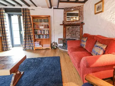 a living room with a red couch and a fireplace at The Corn Store in Corwen