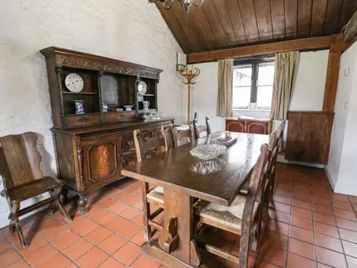 a dining room with a wooden table and chairs at The Dairy in Corwen