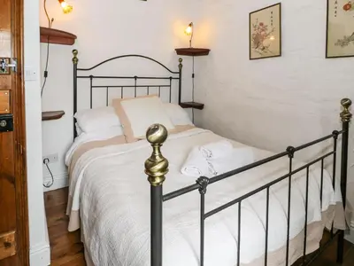 a bedroom with a black and white bed at The Dairy in Corwen