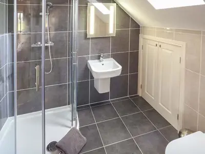 a bathroom with a shower and a sink at Rose Cottage in Winforton