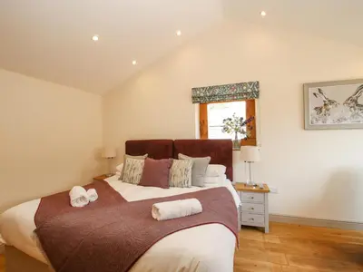 a bedroom with a large bed with two towels on it at The Old Farmhouse in Craven Arms
