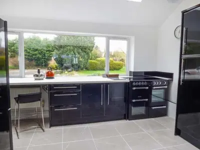 a kitchen with a black stove and a window at The Willows in Ellesmere