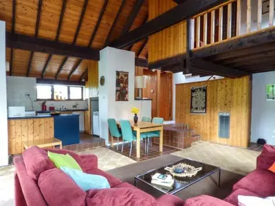 a living room with a red couch and a kitchen at Ty Uchaf in Llangwm