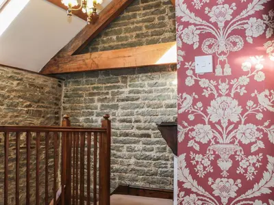 a staircase with a red and white wallpaper at The Granary in Bucknell