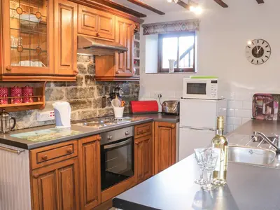 a kitchen with wooden cabinets and a stove top oven at The Granary in Bucknell