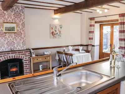 a kitchen with a sink and a fireplace at The Granary in Bucknell