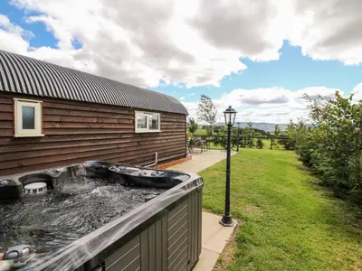a hot tub on the side of a house at Meadow View in Saint Harmon