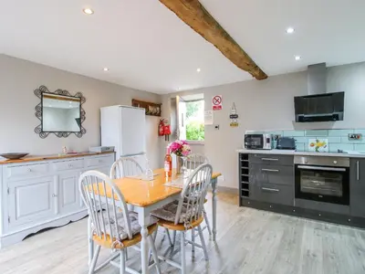 a kitchen with a table and chairs in a room at The Hay Loft in Craven Arms