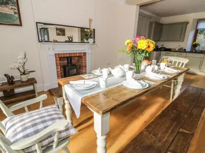 a dining room with a table and a fireplace at Oakwood House in Saint Harmon