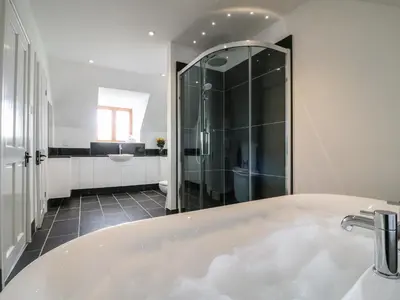 a bathroom with a bath tub and a shower at Oakwood House in Saint Harmon