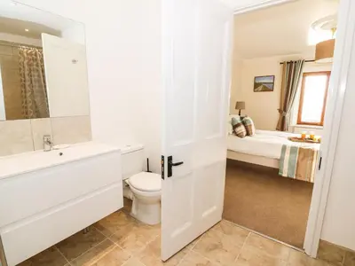 a bathroom with a toilet and a sink and a bed at Oakwood House in Saint Harmon