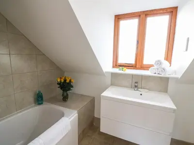 a bathroom with a sink and a bath tub at Oakwood House in Saint Harmon