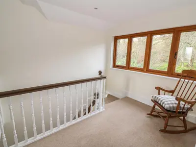 a room with a rocking chair and a window at Oakwood House in Saint Harmon