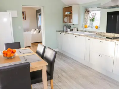 a kitchen and dining room with a table and chairs at Swallow Barn in Walford